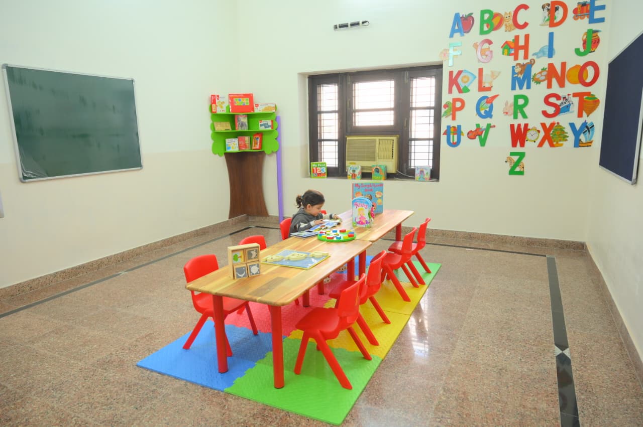 Children playing happily on the preschool playground in front of the school building